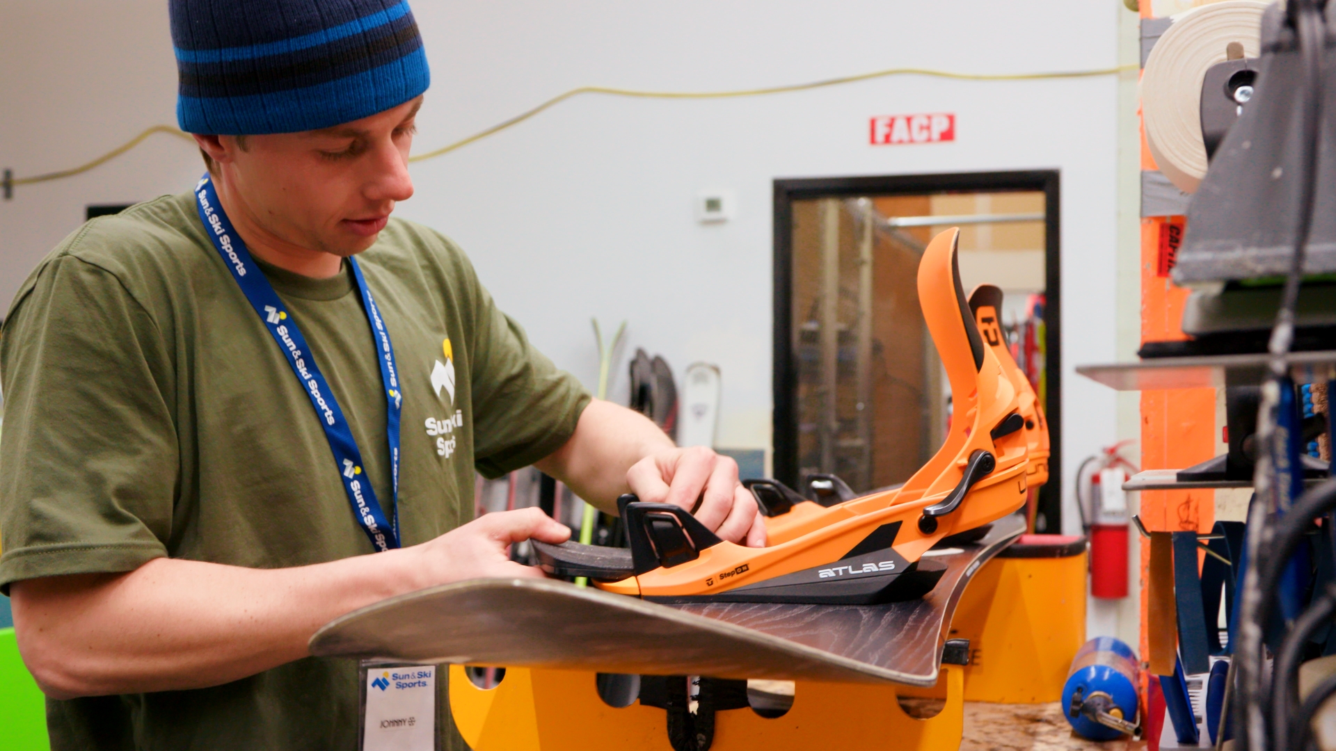 A Sun & Ski Sports Outdoor Expert repairing a snowboard